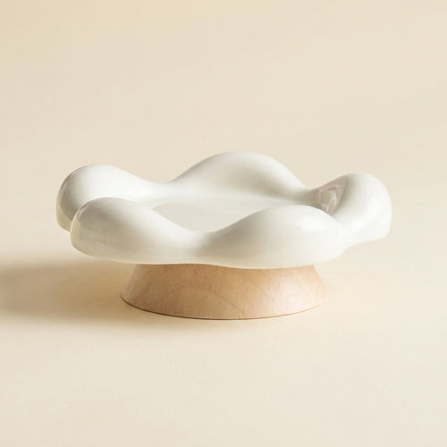 Blossom ceramic cat plate, a shallow cream petal shaped dish on a small wooden base