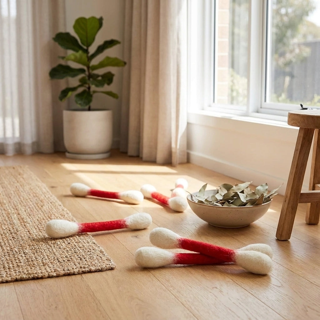 Giant felt cotton bud cat toys on a rug in a bright modern home