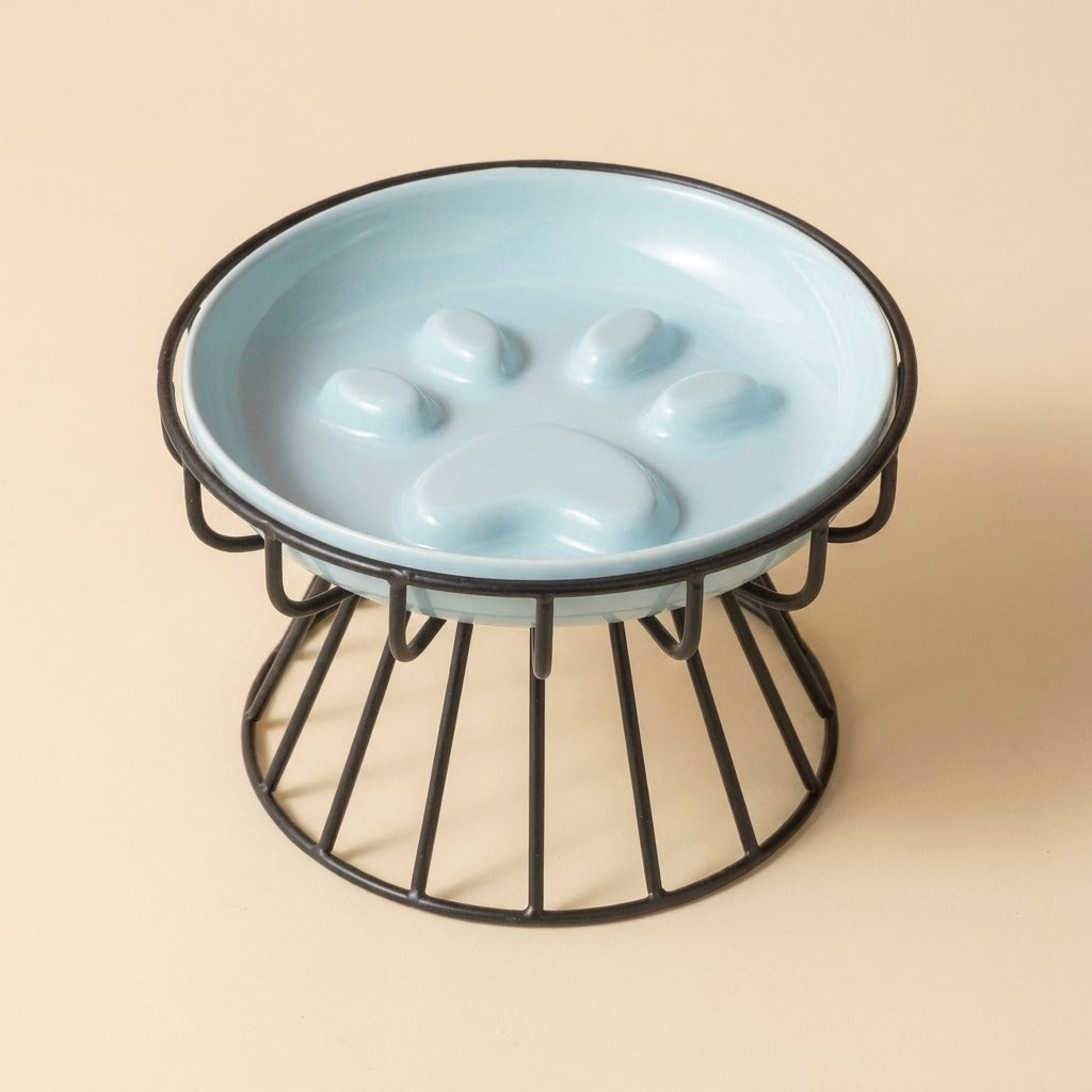 Paw Print Slow Feed Cat Plate in blue on wire stand, studio shot
