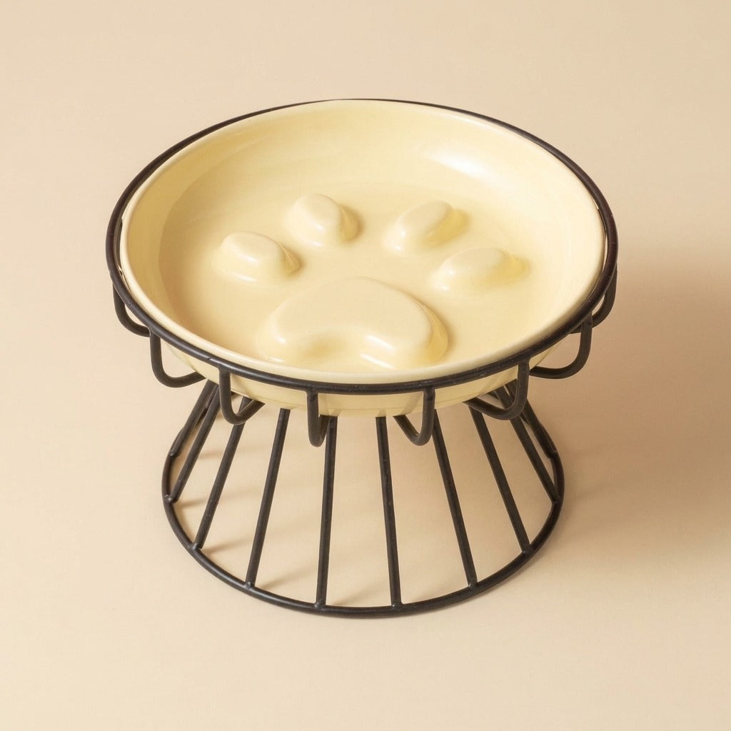Paw Print Slow Feed Cat Plate in yellow on wire stand, studio shot