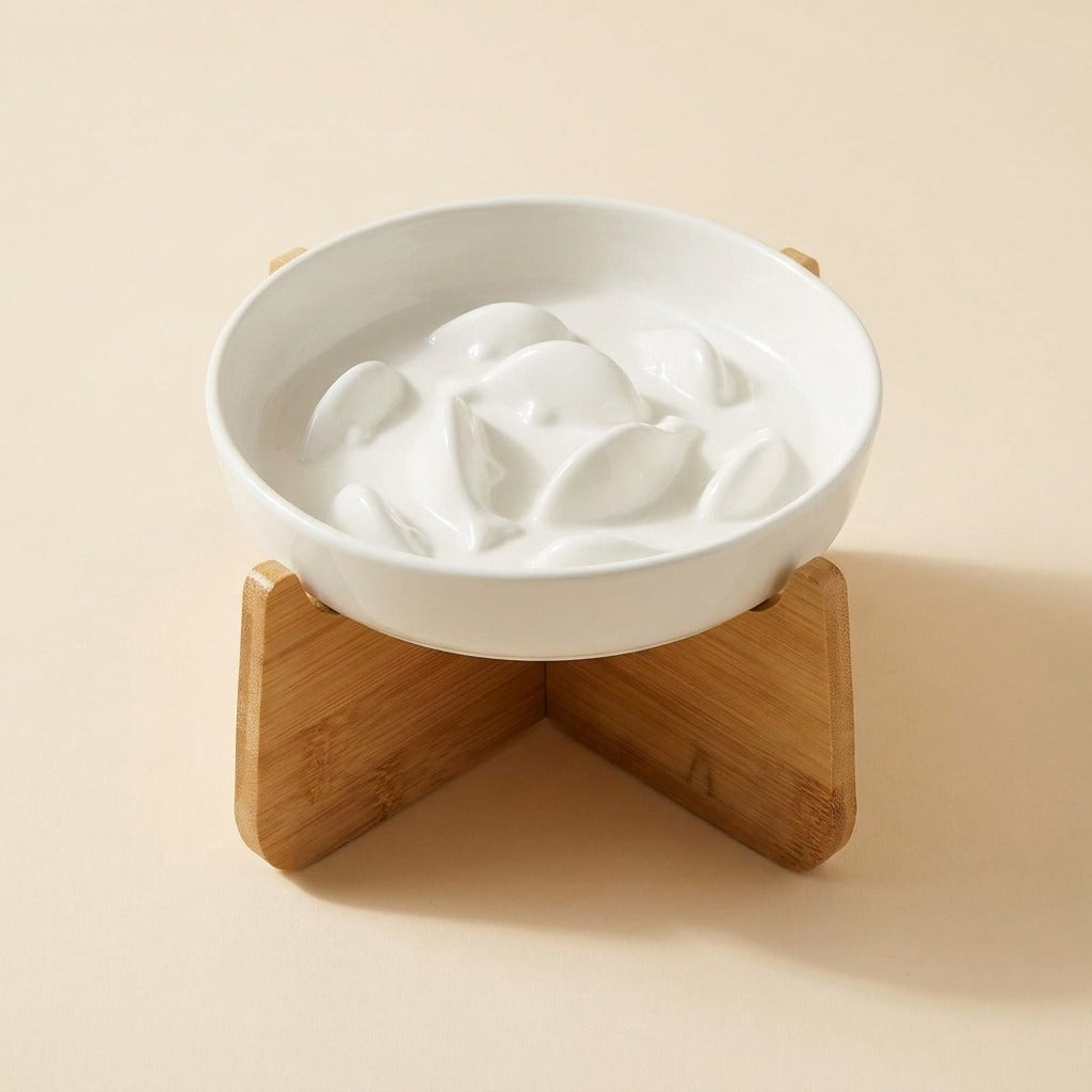 Ceramic Slow Feeder Cat Bowl in white on bamboo stand, studio shot